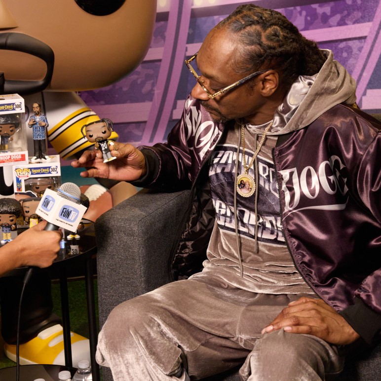 Snoop Dogg poses with a Funko Pop! collectible at the opening of Tha Dogg House retail store.
